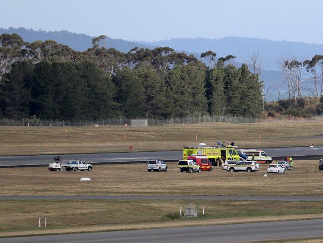 Emergency services attend the helicopter crash at Hobart Airport. Picture: LUKE BOWDEN