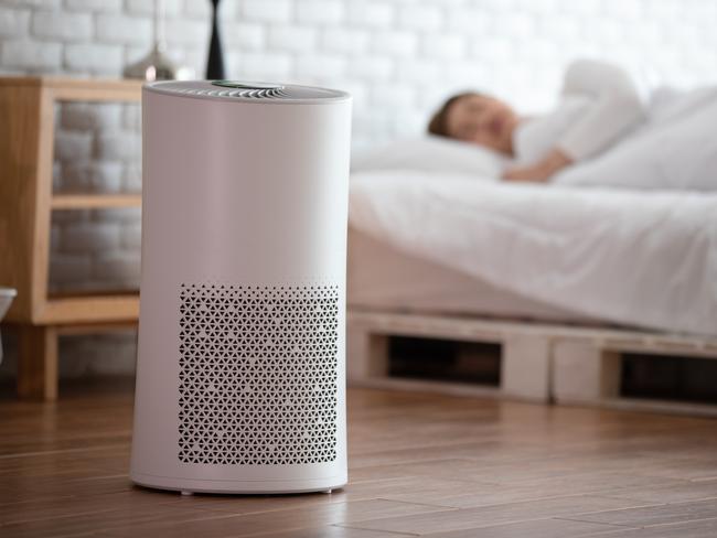 woman sleep with Air purifier in cozy white bed room for filter and cleaning removing dust PM2.5 HEPA in home,for fresh air and healthy life,Air Pollution Concept