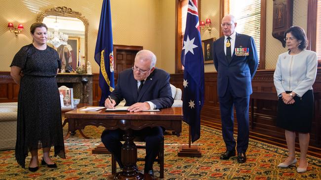 Prime Minister Scott Morrison signing a book of condolence to pay his respects to Prince Philip.