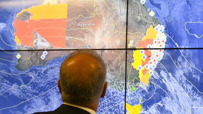 Prime Minister Scott Morrison surveys the bushfire situation in New South Wales and Queensland during a visit to the Australian Government Crisis co-ordination Centre in Canberra. Picture: AAP Image/Lukas Coch