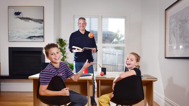 Mitcham dad Jonathan Lawson with his children Ethan, 14, and Mia, 10, at cardboard desks. Picture: Nicki Connolly