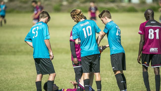 Chancellor players help opponent Mohammed Safdari with leg cramp. Picture: Richard Walker