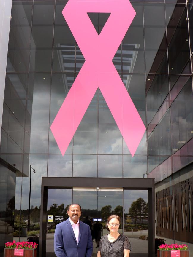 Sudha Sudharshan from Space Real Estate, Oran Park, and Camden Mayor Theresa Fedeli in front of Camden Council administration building in Oran Park with a pink ribbon above the doors for Breast Cancer Awareness month.