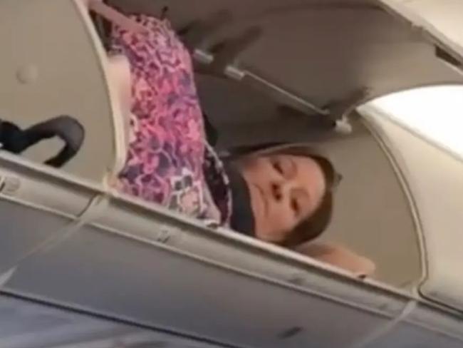 A video of a woman laying in the overhead compartment of a budget airline is being investigated by the carrier.