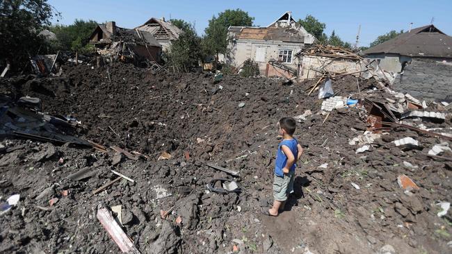 boy looks into a crater following a strike in Druzhkivka village, in Ukraine’s Donetsk region. Picture: AFP