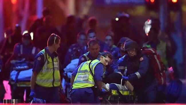 Australian paramedics work on an injured hostage as hostages are carried out. Picture: AFP Photo