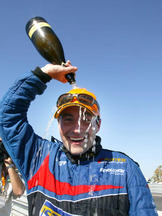 Driver Marcos Ambrose pours bottle of champagne on his head after winning V8 Supercars round in Hidden Valley in 2003.