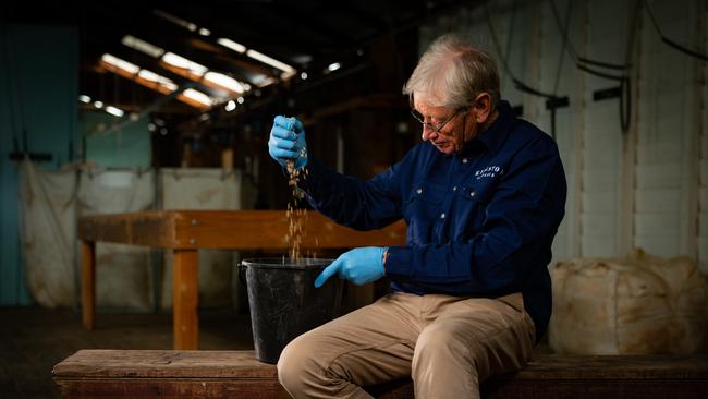 Cameron in the wool shed with stock feed that includes seaweed extract.