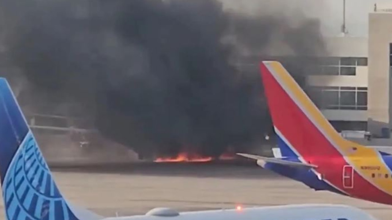 Passengers were forced to stand on one of the planes wings as smoke billowed. Picture: Stone/X