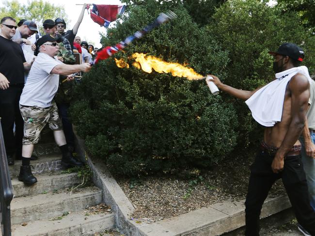 A counter-demonstrator uses a lit spray can against a white nationalist demonstrator. Picture: AP Photo/Steve Helber