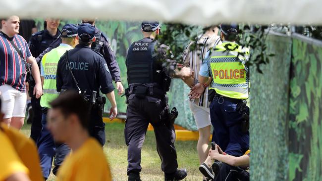 A festival goer is escorted by police Picture: News Corp