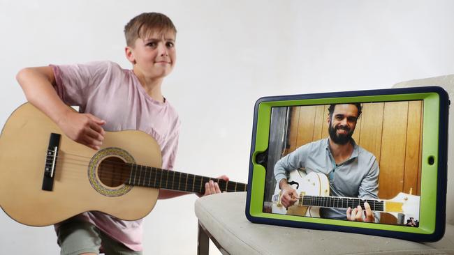 Ashton, 9, has a guitar lesson online with Adam Pallozzi of Junior Rockers. Picture: Michael Klein