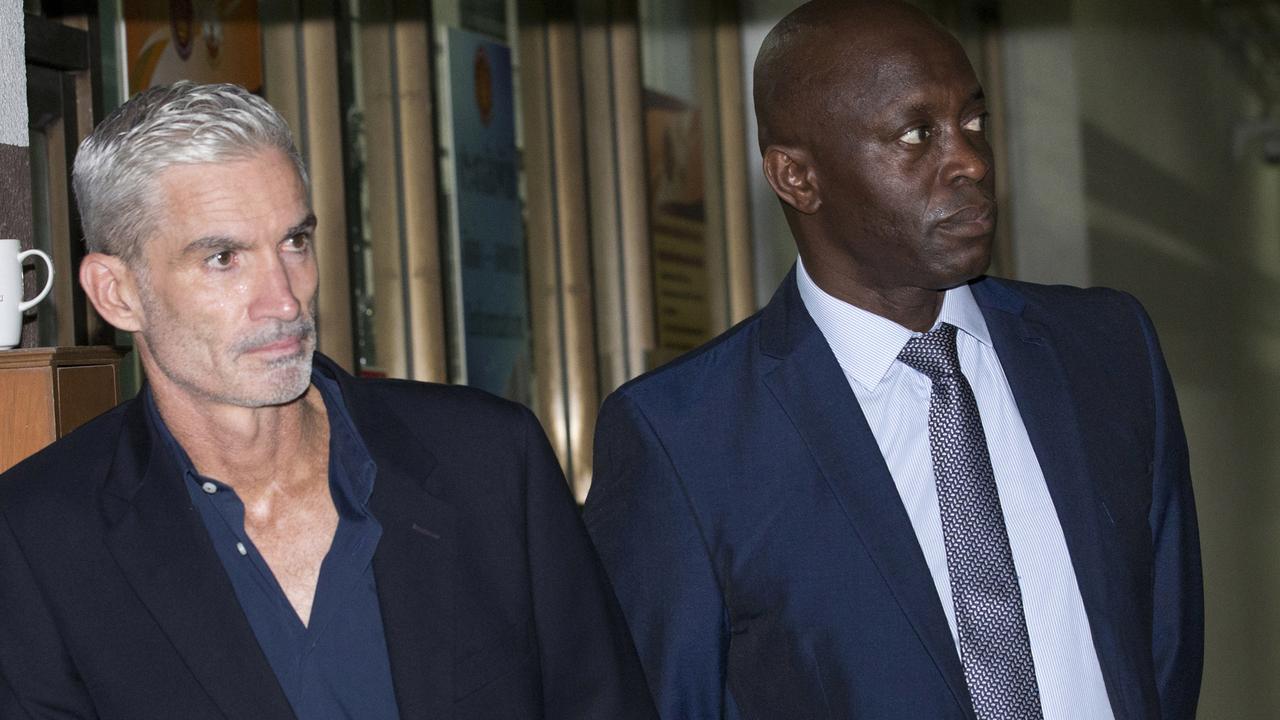 Former Australian soccer national team member Craig Foster, left, and Vice President of FIFPro Francis Awaritefe wait to meet detained Bahraini soccer player Hakeem al-Araibi as he arrives at the criminal court in Bangkok last week. Picture: AP Photo/Sakchai Lalit.