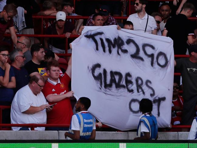 Manchester United fans hold up an anti-Glazer banner in the crowd during the English Premier League football match between Brentford and Manchester United at Brentford Community Stadium in London on August 13, 2022. (Photo by Ian Kington / AFP) / RESTRICTED TO EDITORIAL USE. No use with unauthorized audio, video, data, fixture lists, club/league logos or 'live' services. Online in-match use limited to 120 images. An additional 40 images may be used in extra time. No video emulation. Social media in-match use limited to 120 images. An additional 40 images may be used in extra time. No use in betting publications, games or single club/league/player publications. /