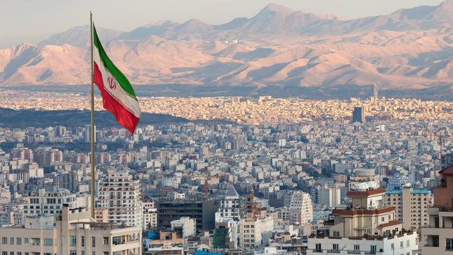 The Iranian flag flies above Tehran’s skyline. Picture: iStock.