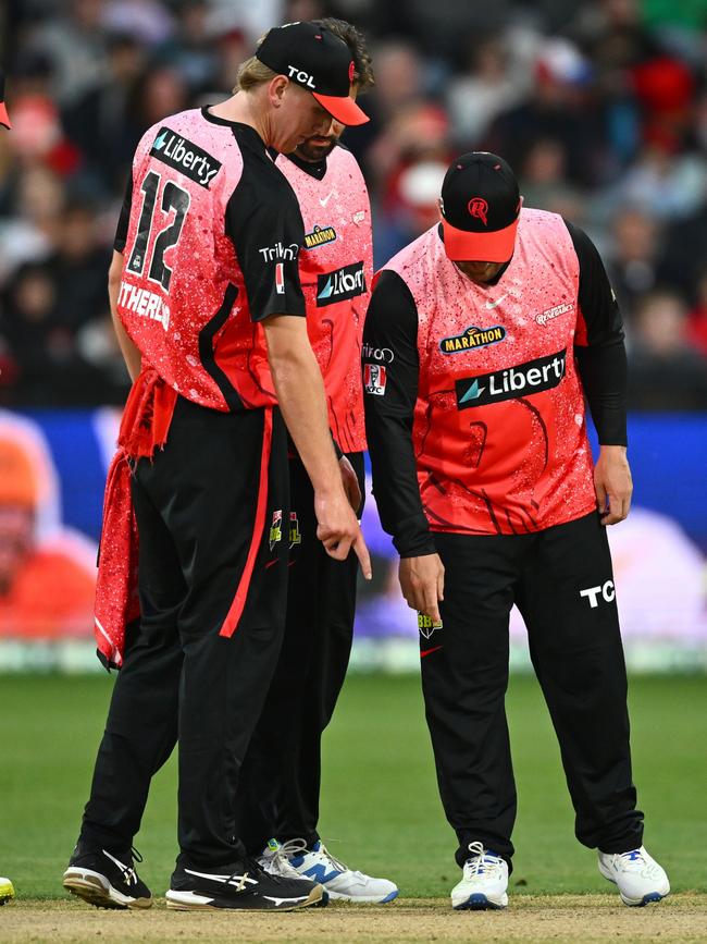 Players inspect the pitch before it was called off. (Photo by Quinn Rooney/Getty Images)