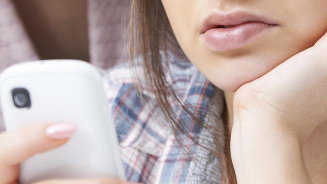 Mother Comforting Daughter Being Bullied By Text Message - Stock Image