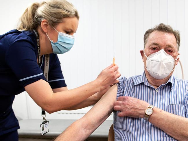 Advanced nurse practitioner Justine Williams (L) prepares to administer a dose of the AstraZeneca/Oxford Covid-19 vaccine to 82-year-old James Shaw, the first person in Scotland to receive the vaccination, at the Lochee Health Centre in Dundee on January 4, 2021. (Photo by Andy Buchanan / POOL / AFP)