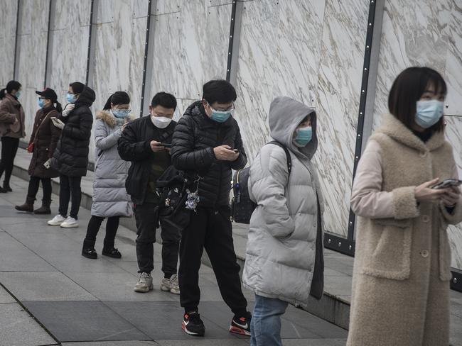 People wearing face masks line up to enter Wuhan international plaza in Hubei Province, China. Picture: Getty Images