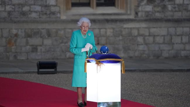 The Queen prepares to touch the Commonwealth Nations Globe to start the lighting of the Principal Beacon outside of Buckingham Palace as part of Platinum Jubilee celebrations on June 2.