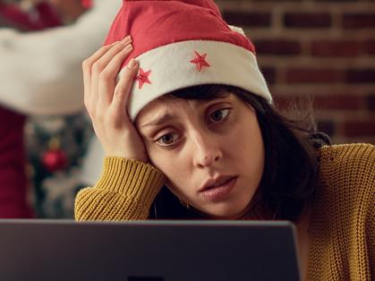 Festive people disturbing stressed woman during christmas time, feeling frustrated by noisy colleagues. Coworkers celebrating winter holiday season, interrupting tired person. Tripod shot. Picture: iStock