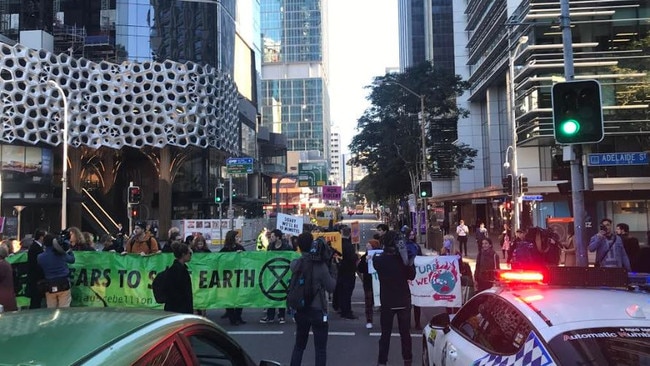 Protesters have been heckled by pedestrians as they stop traffic at the intersection of George and Adelaide streets in Brisbane's CBD. Picture: Andrea Macleod