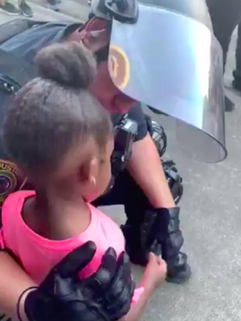 The cop assures the young girl that she is safe.