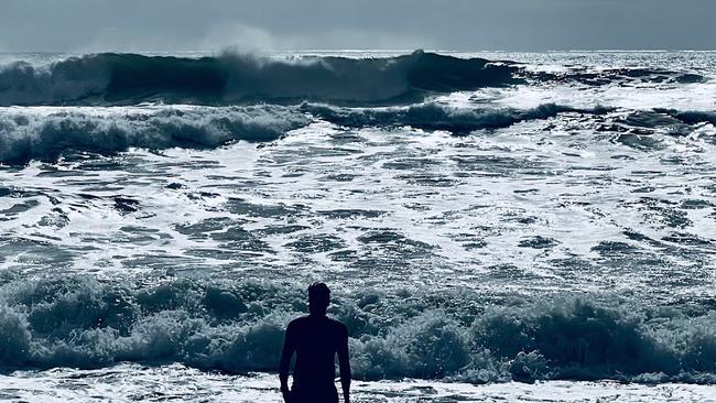 A swimmer enters the water for a quick swim near after a tsunam alert. Picture: Mark Furler