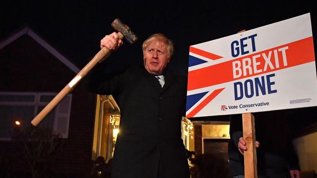 Boris Johnson poses after hammering a Get Brexit Done sign into the garden of a supporter on the final days of campaigning. Picture: Ben Stansall/Getty