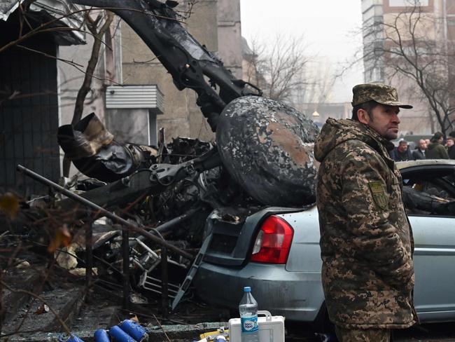 A military stands at the site where a helicopter crashed near a kindergarten outside the capital Kyiv, killing Sixteen people, including two children and Ukrainian interior minister, on January 18, 2023, amid the Russian invasion of Ukraine. (Photo by Sergei SUPINSKY / AFP)