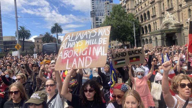 Protesters display signs supporting Indigenous land rights in the Melbourne rally. Picture: Angus McIntyre