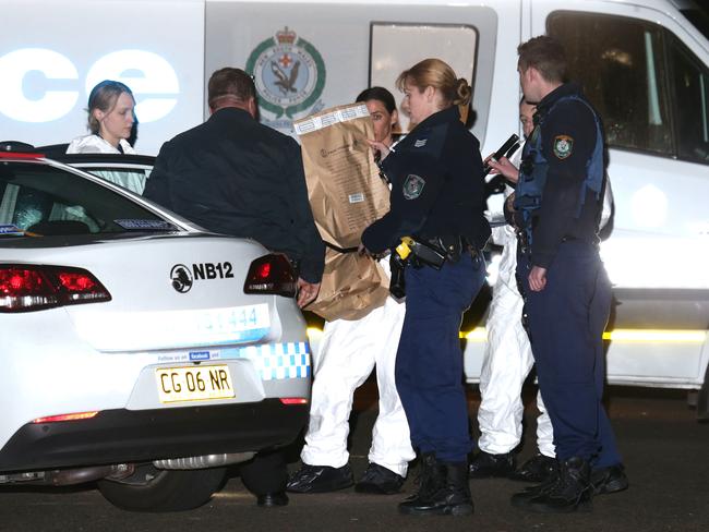 Policewith bags of evidence taken from the home last night. Picture: Bill Hearne