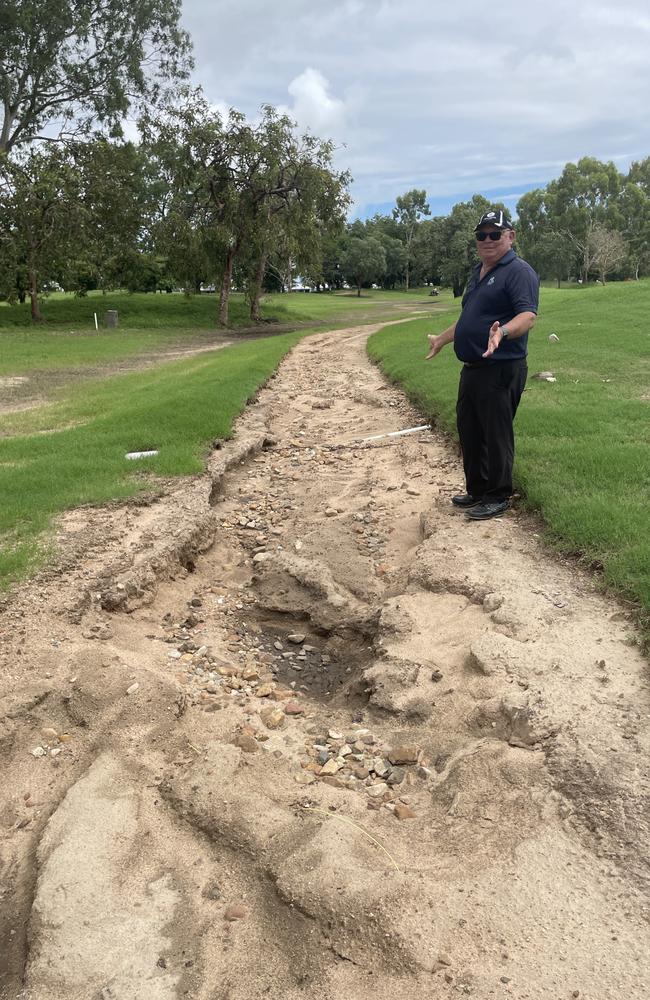 Townsville Golf Club: Club president Danny McLoughlin beside a heavily washed out cart path damaged when the Ross River cut onto the course.