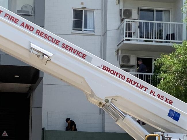 Police officers attempt to negotiate with the man after he climbed across two apartment balconies and into an alcove above the apartment block driveway. Picture: Sarah Matthews