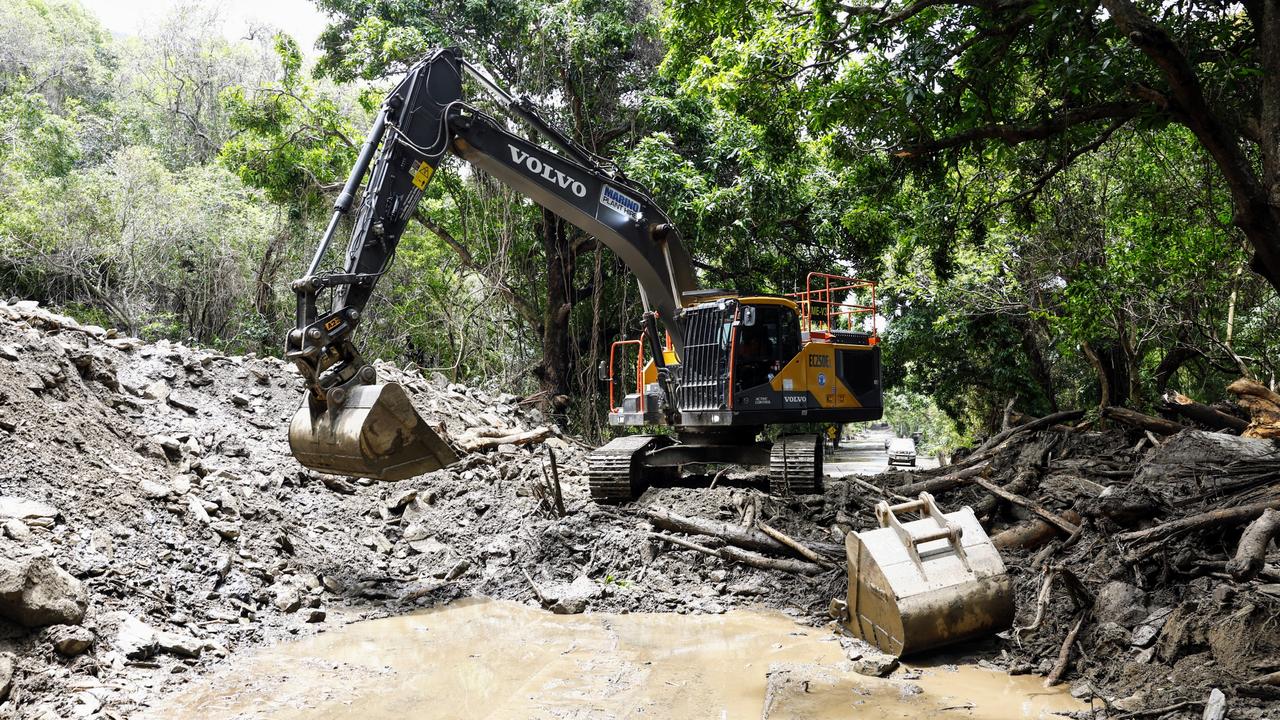 An excavator clears debris from a huge landslide covering the Captain Cook Highway at Ellis Beach. Debris including mud, rocks and tree vegetation completely cut the Captain Cook Highway after flooding caused by ex Tropical Cyclone Jasper created devastation across the Cairns region. Picture: Brendan Radke