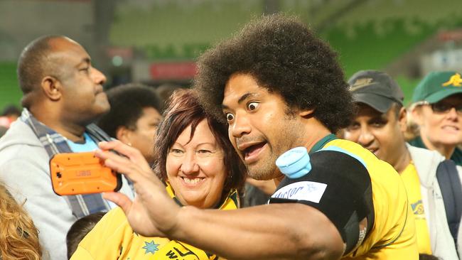 Tatafu Polota-Nau of the Wallabies signs autographs for supporters in the crowd.