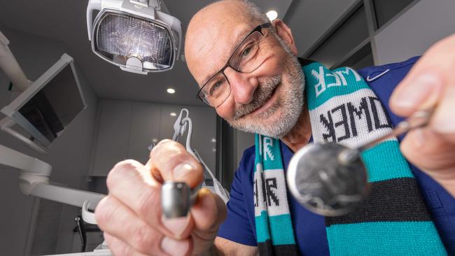 Mad keen Port Adelaide fan Dentist Dr Andrew Nakone, who is a dentist at his clinic at Port Adelaide. Picture: Ben Clark