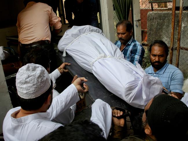 People carry the body of Indian man Hasnain Warekar, after autopsy from a hospital in Thane, outskirts of Mumbai, India, Sunday, Feb. 28, 2016. Warekar, 35 fatally stabbed 14 members of his family, including seven children, early Sunday before hanging himself, police said. (AP Photo/Rajanish Kakade)