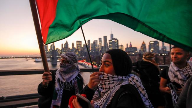 Demonstrators hold Palestinian flags as they march through Brooklyn Bridge during a rally in support of Palestinians in New York. Picture: AFP