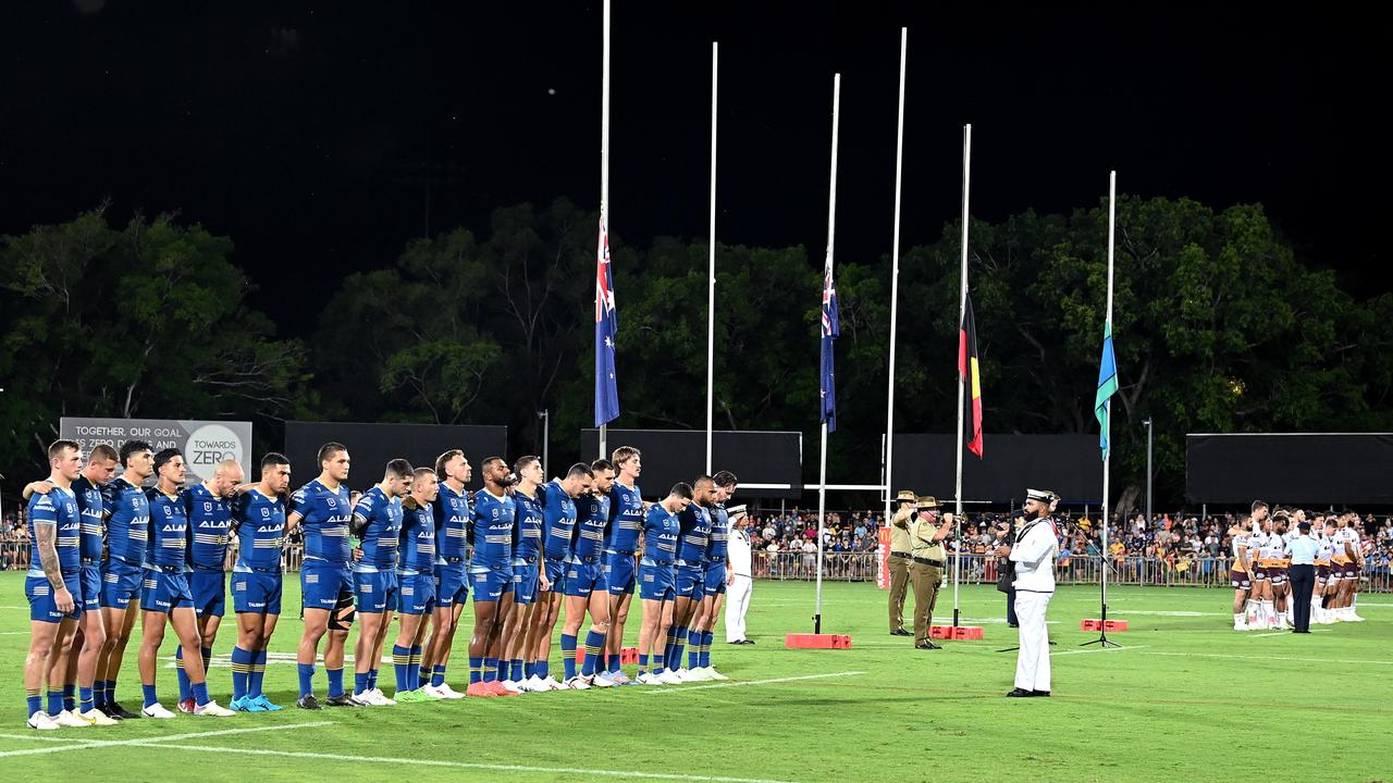 Players embrace for the last post played in remembrance of ANZAC Day at TIO Stadium on April 21, 2023 in Darwin. (Photo by Bradley Kanaris/Getty Images)