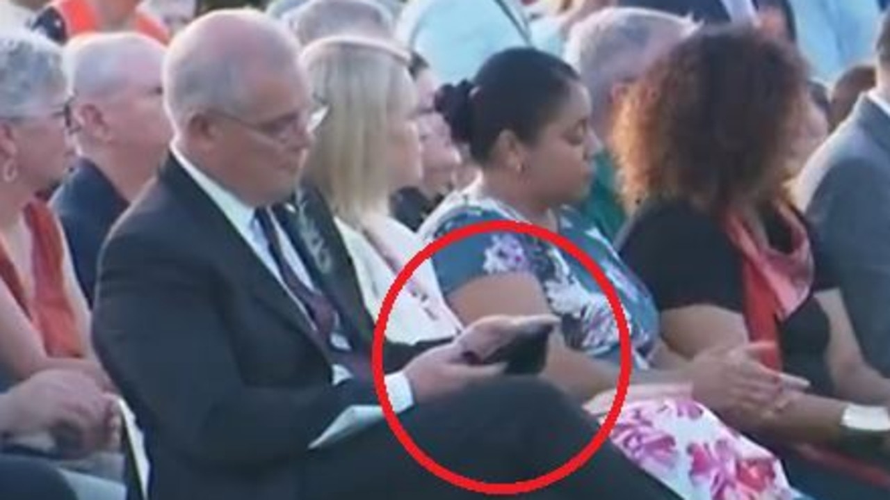 Scott Morrison on his phone during an Anzac Day service in Darwin.