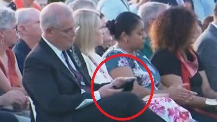 Scott Morrison on his phone during an Anzac Day service in Darwin.