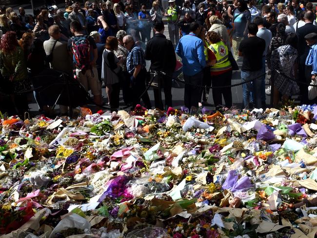 Mourners gather at the Bourke Street memorial, where an unlicensed security guard was seen carrying a gun he didn’t have a licence for. Picture: Nicole Garmston