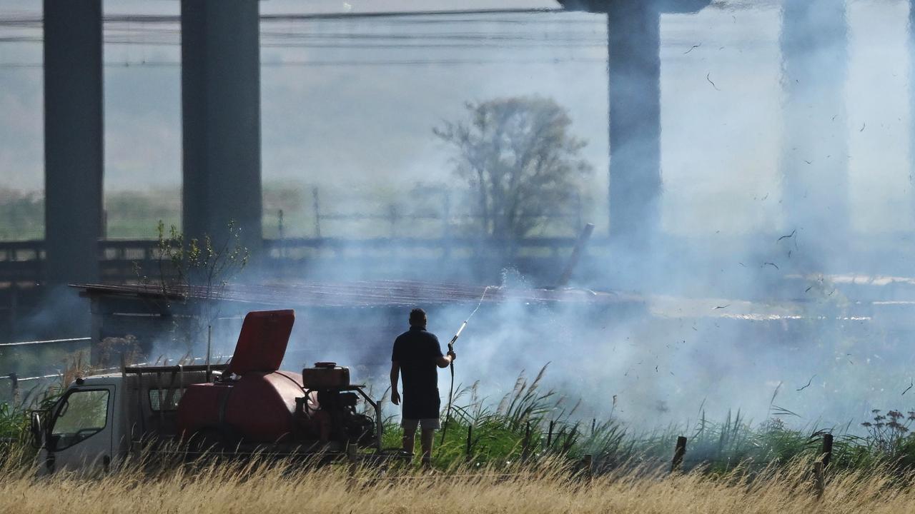 A person tries to douse grass fires that had broken out in the hot weather in Wennington, England. Picture: Getty Images