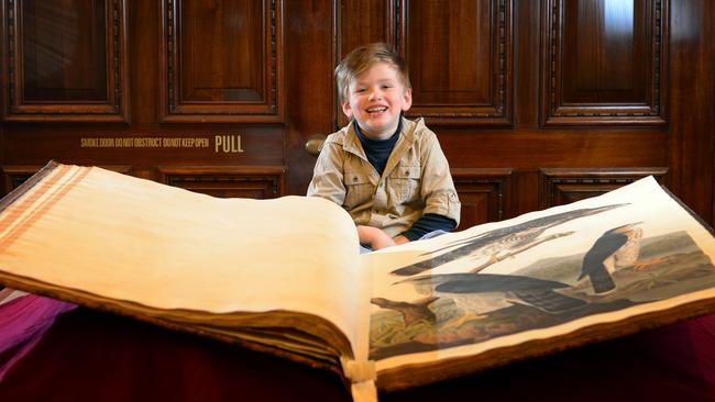 Harrison Corser (5) with the biggest book in the State Library Victoria’s collection 'The birds of America' by John James Audubon (1827-1838).