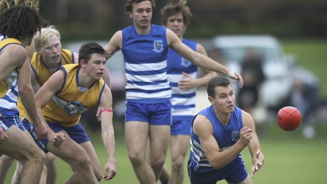 St Peter's Will Warrick handballs in his team’s college football victory against Sacred Heart on Saturday. Picture: AAP/Dean Martin