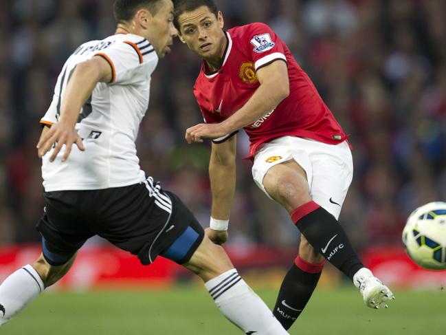 FILE - This is a Tuesday Aug. 12, 2014 file photo of Manchester United's Javier Hernandez as he fires a shot past Valencia's Javi Fuego during a pre season friendly soccer match at Old Trafford Stadium, Manchester, England. Real Madrid has signed Mexico striker Javier Hernandez on a season-long loan from Manchester United. Madrid announced the deal hours before the close of the summer transfer window on Monday Sept. 1, 2014. (AP Photo/Jon Super, File)