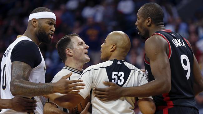 Referees separate New Orleans Pelicans forward DeMarcus Cousins and Toronto Raptors forward Serge Ibaka.