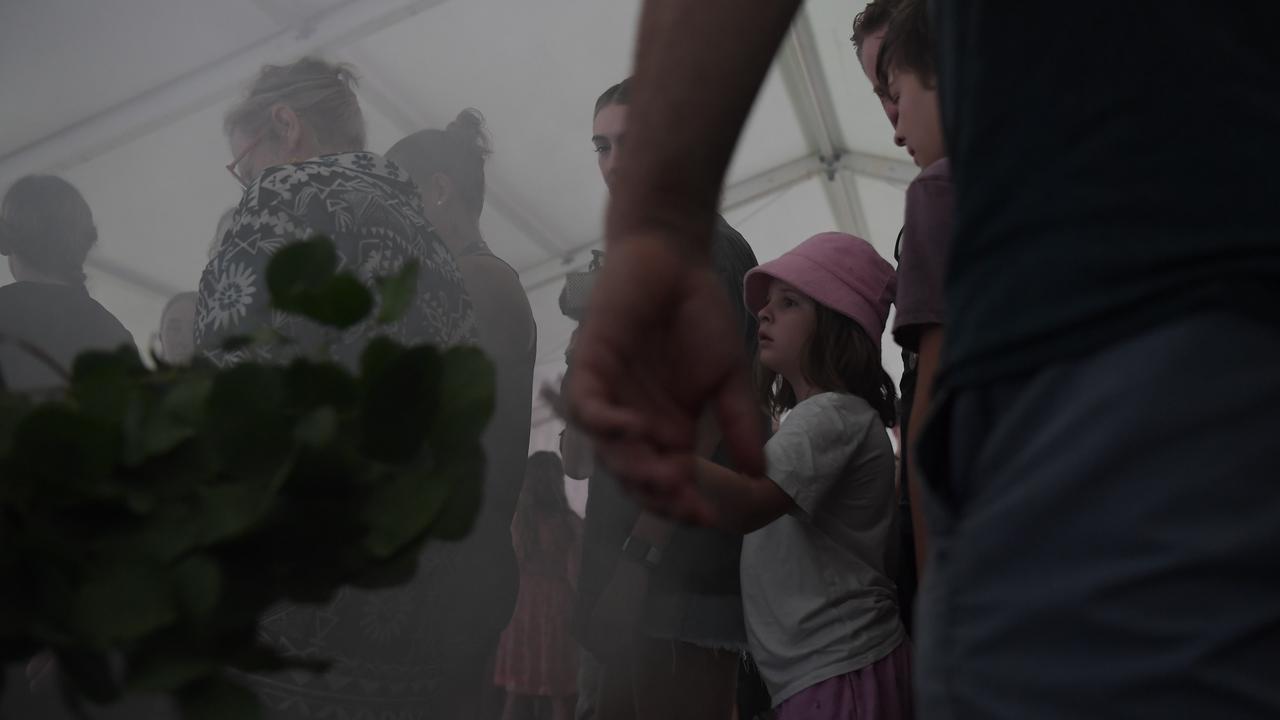 People walk through the smoking ceremony at Darwin Waterfront celebrations. Picture: (A)manda Parkinson