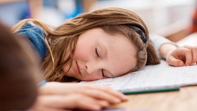 Shot of an elementary school girl sleeping on her desk in class